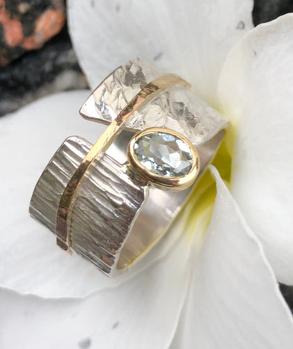 Anel de Prata 950, textura martelada, detalhe e cravação inglesa em ouro 18K. Pedra: Água Marinha.